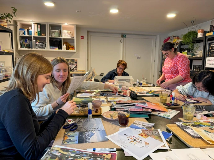 Groep vrouwen samen creatief aan tafel in het Art Atelier van Troostbaar Brugge
